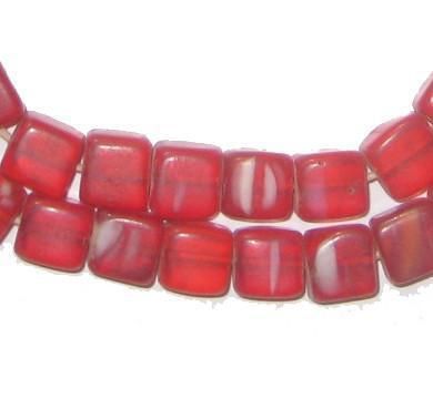 red glass beads are lined up on a white surface