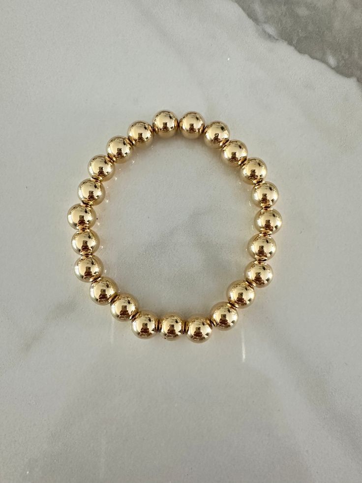 Perfect worn on its own or layered with our other bracelets. 18k gold filled 8mm beads  6", fits up to 6.5" Ready to ship *18k gold filled is a more affordable alternative to solid gold jewelry. Gold filled is a layer of gold bonded onto a base metal with heat and pressure that contains 100+ times more gold than gold plated jewelry.  *It is very durable and tarnish resistant.  *With proper care, gold filled jewelry can last several years. Avoid contact with harsh chemicals, perfumes, water, etc.  *Gold filled jewelry can be worn by people with sensitive skin because it is hypoallergenic, lead free and nickel free. Everyday Yellow Gold Bracelet With 8mm Beads, Classic Gold Beaded Bracelets In 14k Gold Filled, Gold Bracelet With 8mm Beads For Everyday, Elegant 14k Gold-filled Bracelets With 8mm Beads, Everyday Gold Bracelet With 8mm Beads, Classic 14k Gold-filled Bracelets With Gold Beads, Classic 14k Gold Filled Bracelets With Gold Beads, Elegant 14k Gold-filled 8mm Beaded Bracelets, Classic Gold Beaded Stretch Bracelet