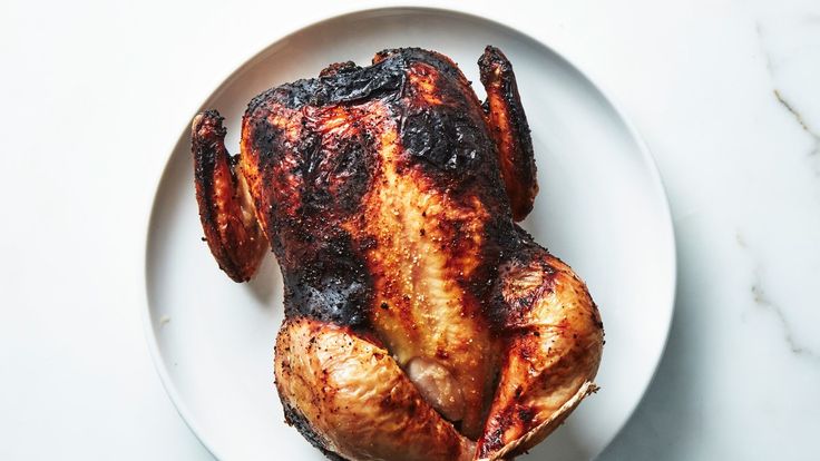 a whole chicken on a white plate