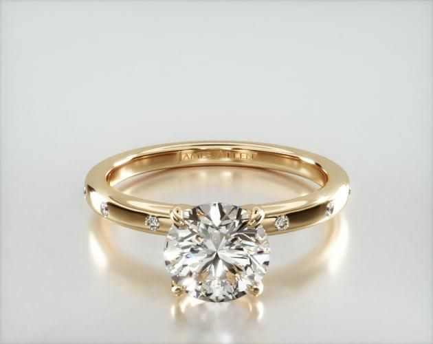 a yellow gold engagement ring with a round diamond