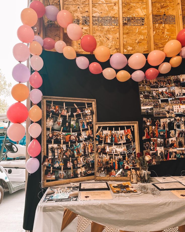 a table with balloons and pictures on it