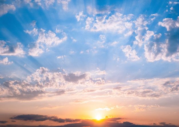 the sun is setting behind some clouds in the sky