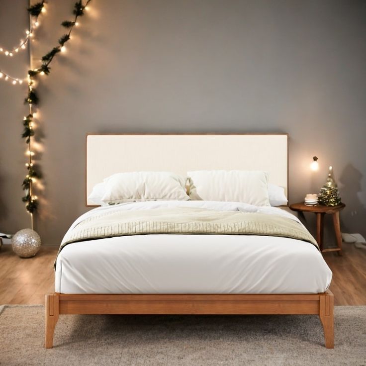 a white bed sitting in a bedroom next to a wall with christmas lights on it