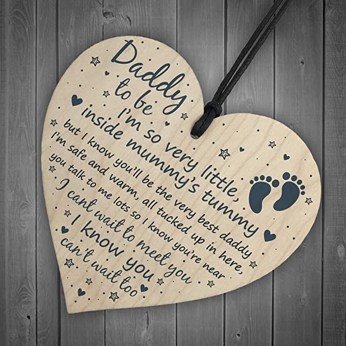 a wooden hanging heart with the words daddy to be engraved on it and a baby's footprints