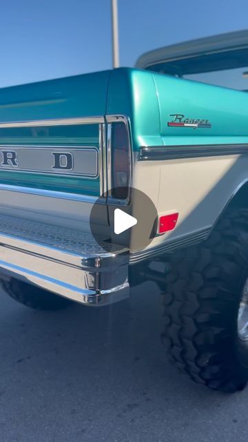 the rear end of a blue truck parked in a parking lot