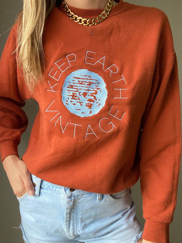 "Upcycled vintage rust colored oversized sweatshirt with baby blue Keep Earth Vintage logo embroidered by small, woman-owned embroidery artist. By purchasing this item, you are supporting a small business, a local embroidery artist and saving a piece of clothing from potentially ending up in a landfill or incinerator while receiving a one-of-a-kind sweatshirt! 50% cotton | 50% polyester | M Recommended for size S-XL depending on desired drape & styling but please always refer to measurements as Vintage Embroidered Cotton Sweater, Vintage Embroidered Text Sweatshirt For Winter, Vintage Winter Sweatshirt With Embroidered Text, Vintage Relaxed Fit Top With Embroidered Logo, Brown Fall Sweatshirt With Embroidered Logo, Brown Sweatshirt With Embroidered Logo For Fall, Vintage Long Sleeve Tops With Embroidered Text, Vintage Cotton Sweatshirt With Embroidered Logo, Vintage Embroidered Logo Sweatshirt For Fall