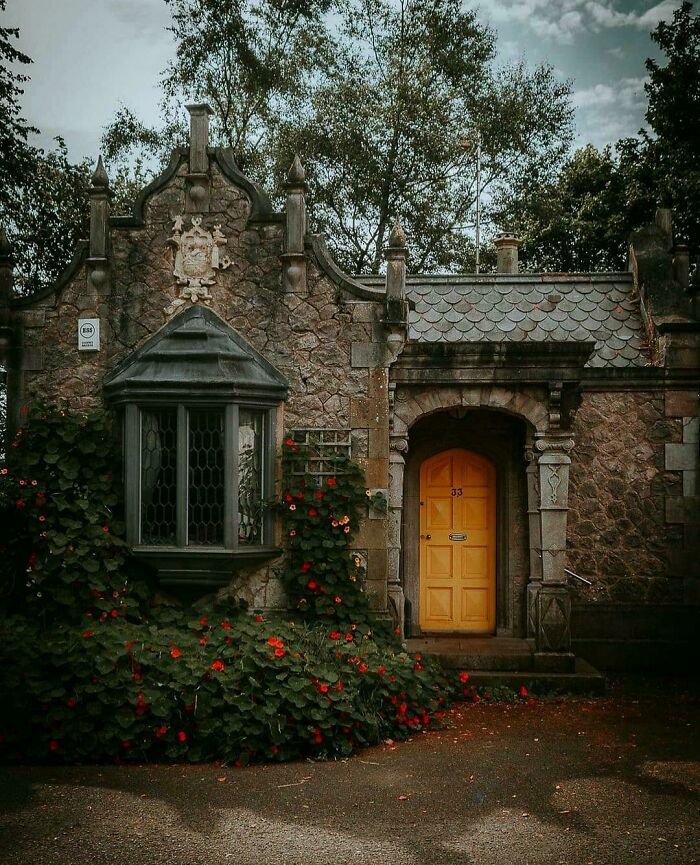 an old stone house with roses growing around it