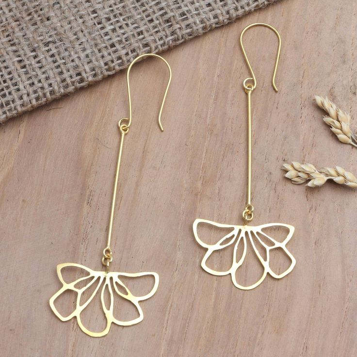 Two openwork flowers dangle from golden stalks on Wayan Karang's earrings which are designed to sway as you move. Using 22k gold-plated brass Balinese artisan hand craft the earrings skillfully twisting the shimmering wires into the floral motif. Gold Filigree Drop Flower Earrings, Gold Brass Flower-shaped Earrings, Pierced Brass Dangle Flower Earrings, Gold Brass Flower Earrings Pierced, Delicate Gold Brass Flower Earrings, Brass Drop Earrings With Flower Detail, Delicate Gold Linear Earrings Pierced, Delicate Gold Linear Earrings, Hand Craft