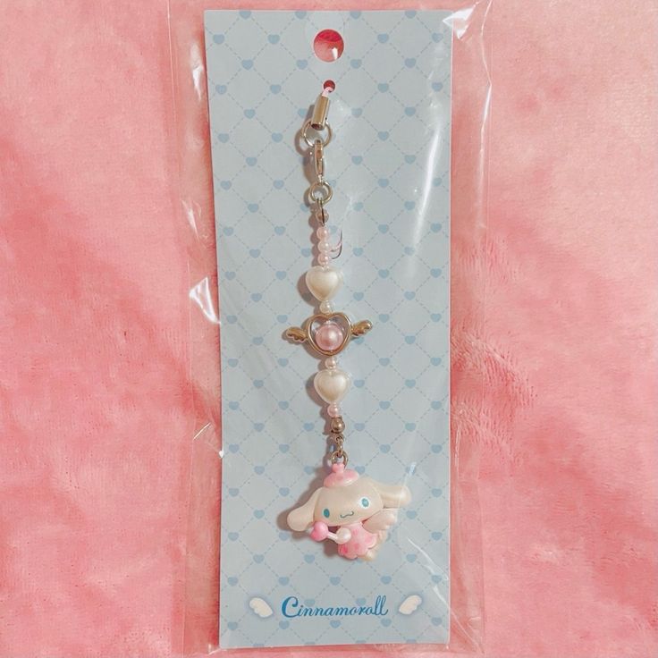 a key chain with an elephant and heart charm on it's end is packaged in a package