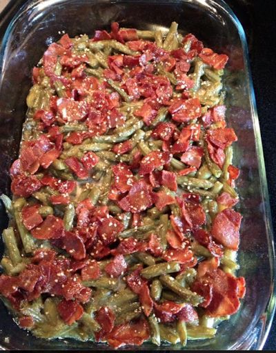 a casserole dish with green beans, tomatoes and other toppings on it