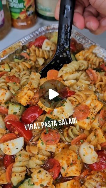 a pan filled with pasta and vegetables on top of a table