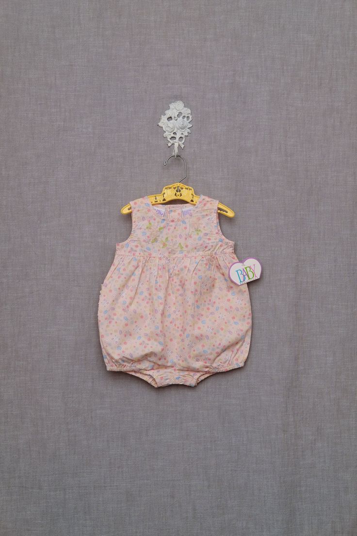 Vintage baby romper in a floral butterfly print fabric.  Romper is sleeveless, with sheer flower rosettes at the chest, and a ruffled seat.  Buttons at back, snaps at seat. New with tags. Marked size 6-9 months, but please check measurements for fit:    10 1/2" under arms. 16 1/2" shoulder to seat. In excellent, never worn, vintage condition, with tag still attached. Sweet Fitted Bubble Romper For Spring, Floral Print Fitted Cotton Bubble Romper, Pink Floral Print Bubble Romper For Playtime, Sleeveless Bubble Romper For First Birthday In Spring, Playful Sleeveless Bubble Romper With Floral Print, Pink Fitted Floral Print Bubble Romper, Pink Floral Print Sleeveless Bubble Romper, Pink Sleeveless Bubble Romper For First Birthday, Sleeveless Summer Bubble Romper With Floral Print