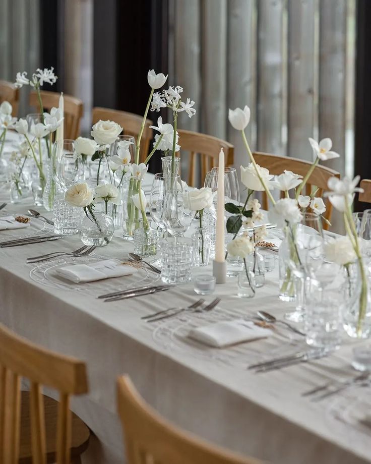 the table is set with white flowers and place settings for an elegant dinner or party