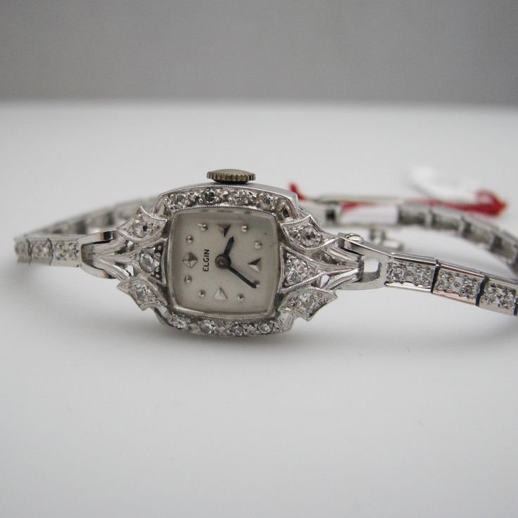 "For sale: (1) g123 14k White Gold Women's Diamond Elgin Watch PLEASE READ ENTIRE DESCRIPTION BEFORE PURCHASING Pre-owned item. Good condition. Please see pictures for details. Sold as is, as seen on pictures. This beautiful ladies Elgin Art Deco watch contains 62 diamonds, all of which are round cut. It is stamped. Specifics: 14k White gold Diamonds: .86TCW Mechanical Length: 5.5 inches Case size with crown: 15.9 mm Lug width: 4mm Please be 100% sure of your purchase before buying, as we do not Platinum Diamond Watch With 17 Jewels For Evening, Elegant Platinum Diamond Watch With 17 Jewels, Art Deco Platinum Evening Watches, Platinum Art Deco Evening Watches, Luxury Hallmarked Diamond Watch For Evening, Luxury Hallmarked Diamond Watch For Evenings, Antique Platinum Evening Watches, Elegant Evening Diamond Watch With 17 Jewels, Wedding Platinum Diamond Watch With 17 Jewels