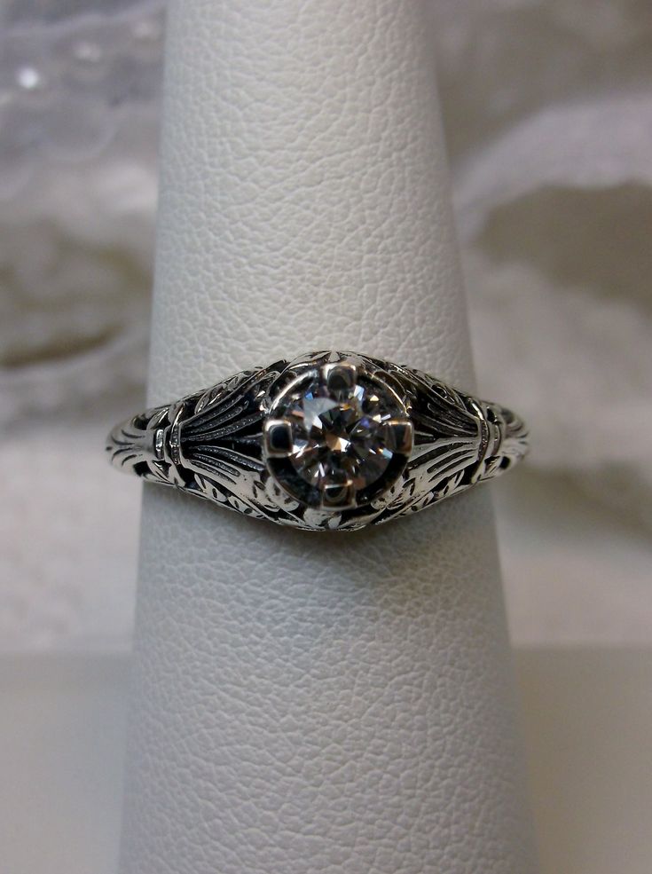 Faux Diamond Sterling Silver Ring Floral Wedding #D154 This is a Victorian era (Edwardian specific) reproduction ring in sterling silver filigree with a lovely white gemstone solitaire. Please choose between a white cubic zirconia (CZ), natural white topaz or lab created moissanite. This full cut round cut gemstone is 4mm in diameter. The inside of the band is marked 925 for sterling silver. Notice the beautiful floral design of the silver filigree setting and band. This is a lovely rendition of Wedding Silver, Antique Filigree, Edwardian Jewelry, Sterling Silver Filigree, Filigree Ring, Cz Ring, Engraved Items, Silver Filigree, Silver Wedding