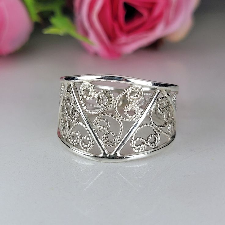 filigree ring made by intricate metal work, creating a rich floral and dainty look. The sterling silver wide ring is inspired by Art nouveau jewelry combined with modern design. This 925 dainty ring is perfect for your beloved one, and as a pampering gift for yourself. The ring is very flattering to the finger, comfortable to wear as a jewel for everyday use and impressive as a jewel for a special occasion. The structure of the ring is approximately 15mm wide at the top, and approximately 3mm narrow at the bottom, creating an impressive elegant look. The ring is made of 925 sterling silver by hand tools only. Each piece of jewelry is handmade to order, therefor due to the special nature of handcrafting, there may be slight differences compared to the jewelry in the photos shown. This adds Elegant Sterling Silver Wide Band Ring For Promise, Elegant Sterling Silver Wide Band Stackable Rings, Elegant Wide Band Open Ring Stamped 925, Elegant Wide Band Ring Stamped 925, Silver Stackable Rings With Intricate Design For Gift, Ornate Sterling Silver Filigree Ring With Intricate Design, Elegant Wide Band Filigree Ring With Intricate Design, Elegant Sterling Silver Wide Band Ring For Wedding, Elegant Wide Band Sterling Silver Ring For Wedding