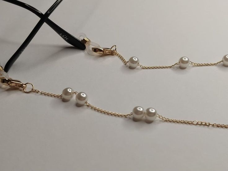 A practical and elegant accessory, this gold brass chain decorated with acrylic pearls is designed to keep your face mask or glasses safe. The length of the chain is 75 cm Protect them from water, perfumes, hair and body lotions to keep them bright and shiny for years. Accessoire pratique et élégant, cette chaîne en laiton doré ornée de perles acryliques est conçue pour protéger votre masque ou vos lunettes. La longueur de la chaîne est de 75 cm. Protégez-les de l'eau, des parfums, des lotions c Elegant Metal Beaded Glasses Chain, Elegant Gold Glasses Chains With Delicate Chain, Elegant Gold Glasses Chain With Delicate Detail, Elegant Gold Glasses Chains For Formal Events, Elegant Gold Chain Glasses Chains, Elegant Gold Glasses Chain With Beaded Detail, Elegant Gold Beaded Glasses Chain, Elegant Everyday Beaded Glasses Chains, Gold Chain Glasses Chains Made Of Glass For Gift