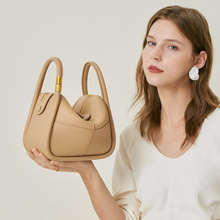 Looking for a versatile shoulder bag that oozes style and quality? Look no further than the Kelly Shoulder Bag! Lightweight and versatile, this bag is perfect for any occasion while easily fitting all your essentials. Whether dressed up or down, you'll confidently go anywhere with this must-have statement piece on your shoulder. Now available in beige and khaki. Versatile Beige Box Bag For Office, Handheld Baguette Bag With Adjustable Strap For On-the-go, Beige Hobo Bag With Top Carry Handle For On-the-go, On-the-go Crossbody Baguette Bag With Top Handle, Modern Beige Shoulder Box Bag, Versatile Handheld Box Bag For On-the-go, Versatile Beige Hobo Shoulder Bag, Beige Leather Baguette Bag For On-the-go, Trendy Top Handle Shoulder Bag For On-the-go