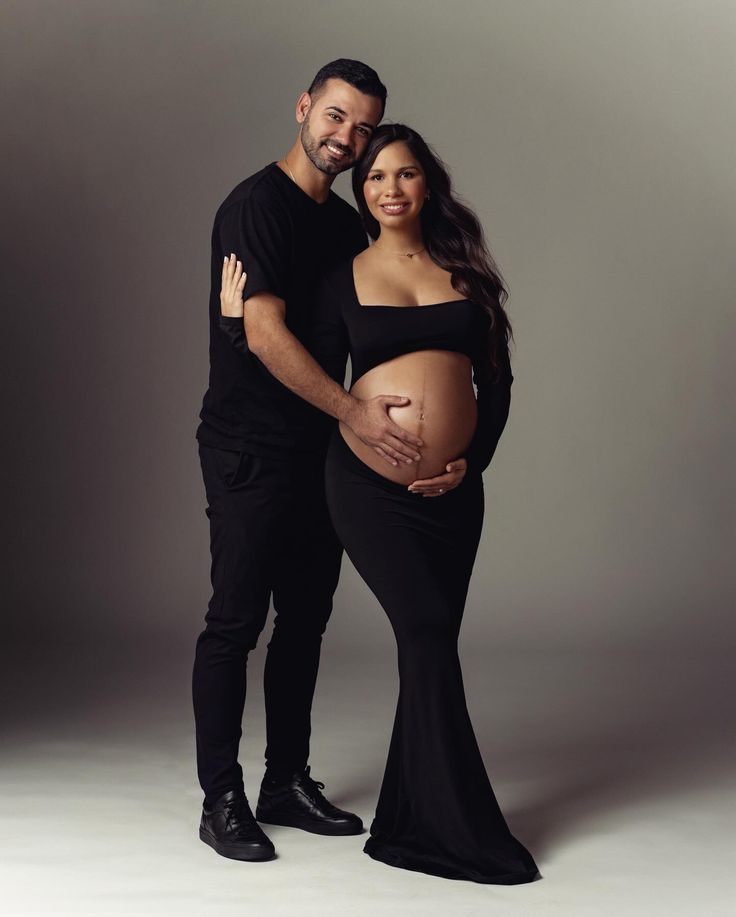 a pregnant couple posing for a photo