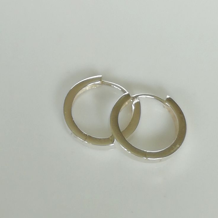 Thick band ear hoops made of sterling silver with a hinged joint. Dimensions: 16 X 2.5 mm Weight: 2.3 gm Price listed is for a pair of hoops. These earrings are made of 925 hypoallergenic sterling silver. All my pieces are sent in a gift box. I can include a personal message from you if needed. You are welcome to contact me at... bhavnakwintra1956@gmail.com More hoops: https://www.etsy.com/your/shops/TheSilverGame/tools/listings/section:26305414 More earrings: https://www.etsy.com/your/shops/The Everyday Silver Metal Huggie Earrings, Minimalist White Gold Huggie Earrings, Minimalist Metal Round Huggie Earrings, Minimalist Round Metal Huggie Earrings, Minimalist Nickel-free Small Hoop Huggie Earrings, Minimalist Metal Hoop Earrings For Everyday, Minimalist Small Hoop Clip-on Earrings, Minimalist Small Hoop Earrings In Metal, Minimalist Small Hoop Metal Earrings