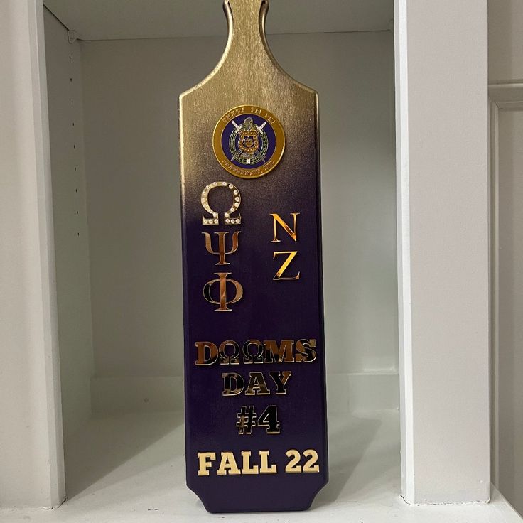 a purple and gold trophy sitting on top of a white shelf