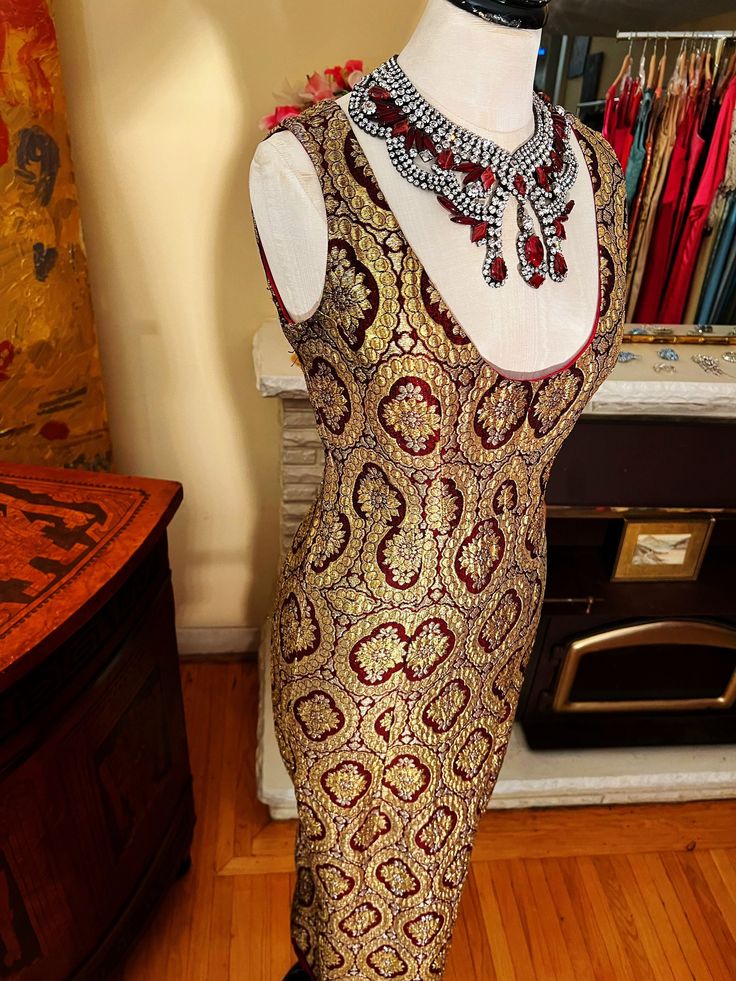 1960's Gold Brocade Vintage Couture Gown This fabric is rich because it was made with gold threads.   The dress is lined in silk oganza and is hand finished. I personally found this dress in Venice from the private residence of a famous artist. Dimensions: Bust:      34-35 inches Waist:    29 inches Hips:      36 inches From shoulder to shoulder:   14 inches From shoulder to bottom of hem:  54 inches Price : $1200 Please note that I have photographed the dress in two different ways:   1) As is, and 2) Pinning the skirt in for those of you who wonder how it would look taken in -to show off your beautiful hips!  I love this store so much.  It is celebrating its 50th Birthday this year.  We are here for you if you any questions ir requests. Thank you very much and have a lovely day!! Fitted Brocade Evening Dress For Party, Festive Brocade Formal Dress, Festive Formal Brocade Dress, Festive Brocade Dress For Formal Occasions, Bollywood Style Gold Sequin Dress, Gold Bollywood Dress With Sequins, Gold Sleeveless Evening Dress For Festive Occasions, Glamorous Gold Dress With Zari Work, Festive Fitted Evening Dress With Zari Work