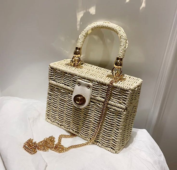 Woven vanity style handbag perfect for your Baecation. Vanity bag style With gold crossbody chain Turn clasp closure Woven Straw material dimensions: 7 * 5 * 3 -inches Available in Natural, Tan, & Black Popular Purses, Women Backpack Travel, Popular Handbags, Vanity Bag, Bags For Teens, Womens Designer Handbags, Woven Chain, Handbags Casual, Woven Tote Bag