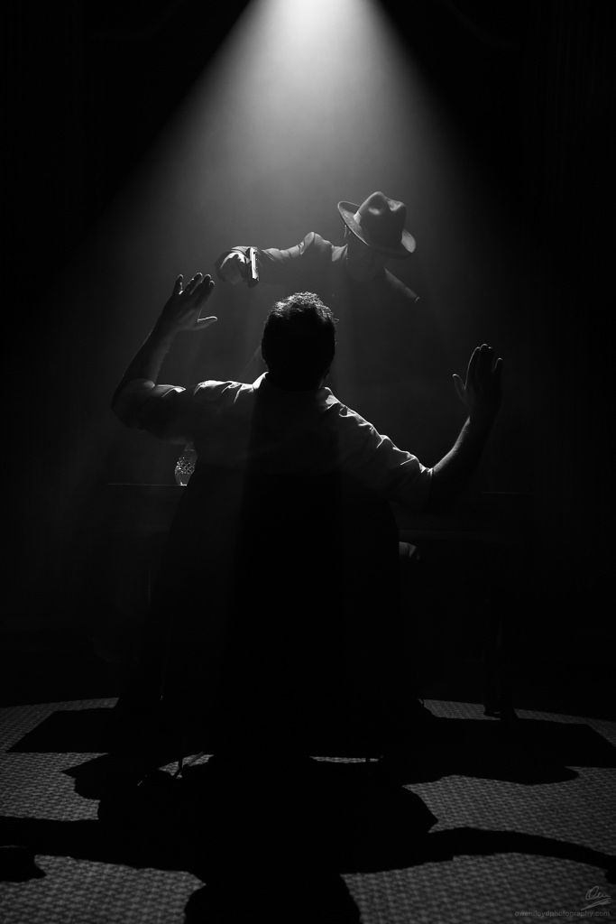 a man sitting on the floor in front of a light that is shining down over him