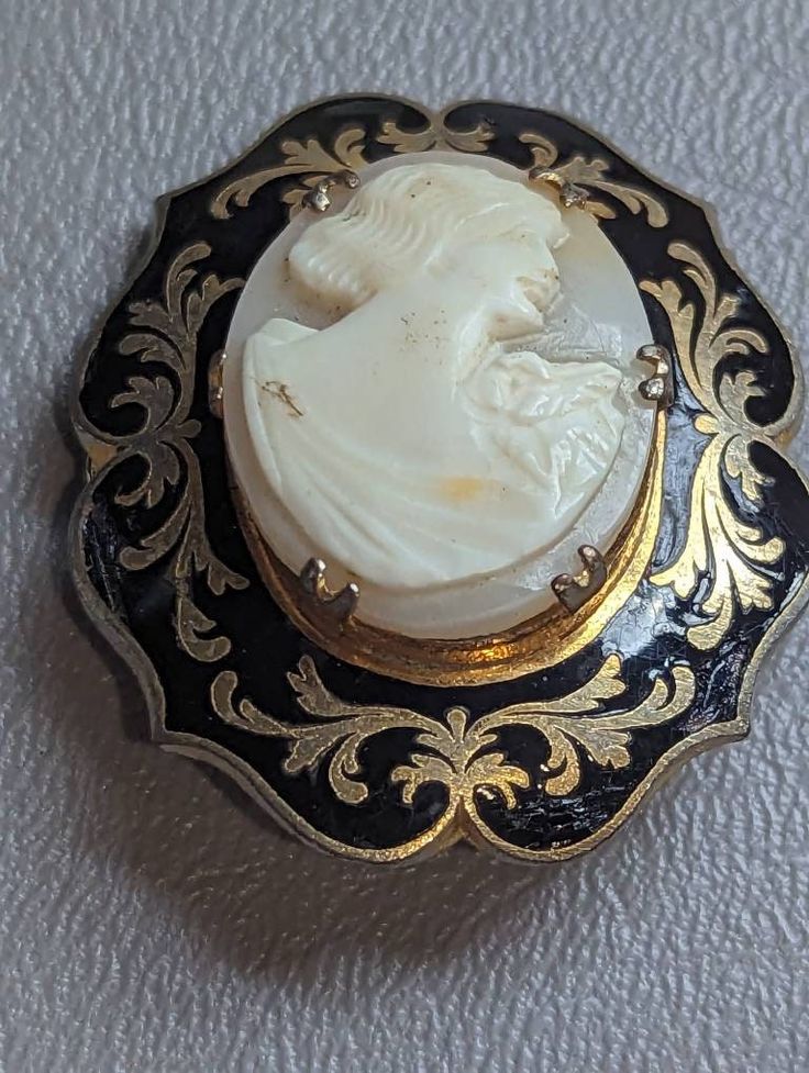 "Antique Shell Cameo & Black Enamel Brooch Pin HALLMARKS Unmarked. MEASUREMENTS 1 3/8\" x 1 5/8\".               MATERIALS Shell, Black Enamel, Gold Gilt. CONDITION In very good condition with minimal wear on gold gilt, please use all pictures as part of item's description. Turn of the Century Edwardian era Mourning Cameo brooch featuring carved shell center of classic Roman or Grecian lady in profile prong set in Black Enamel frame with ornate Gold Gilt designs. This is a very unique cameo. Cam Turn Of The Century, Carved Shell, Cameo Brooch, Enamel Brooch, Edwardian Era, Pretty Earrings, Black Enamel, Silver Turquoise, Turquoise Sterling Silver