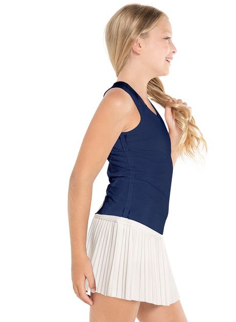 a woman in a blue top and white pleated skirt is posing for the camera