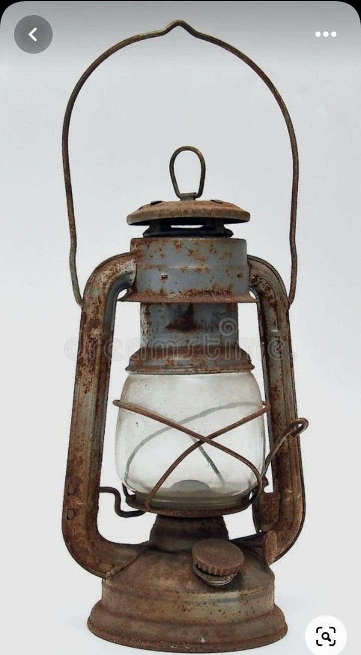 an old rusted metal lantern with a white light inside it on a white background