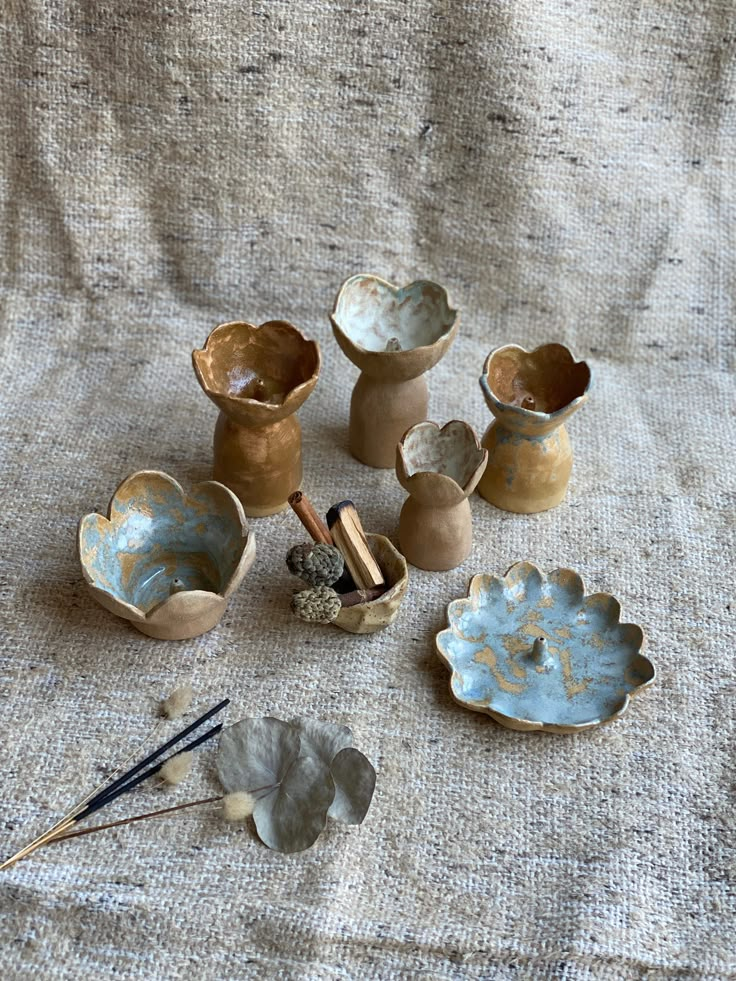 several small vases are sitting on a tablecloth with other items around them, including an ink pen