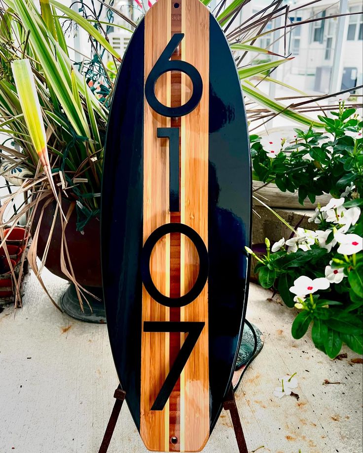 a surfboard with the number forty on it is standing in front of some potted plants