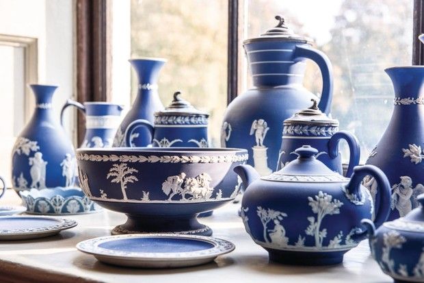 many blue vases and plates on a window sill