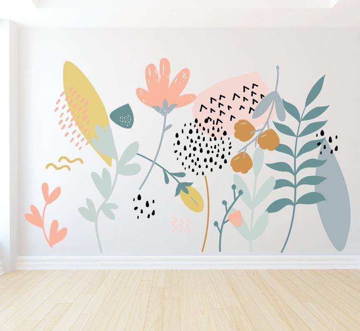 an empty room with flowers painted on the wall and wood flooring in front of it