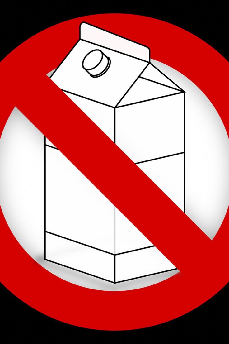 a red and white sign with a carton of milk in it on a black background