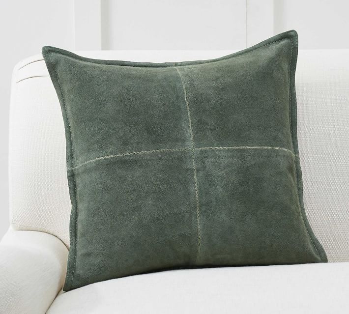 a green pillow sitting on top of a white couch