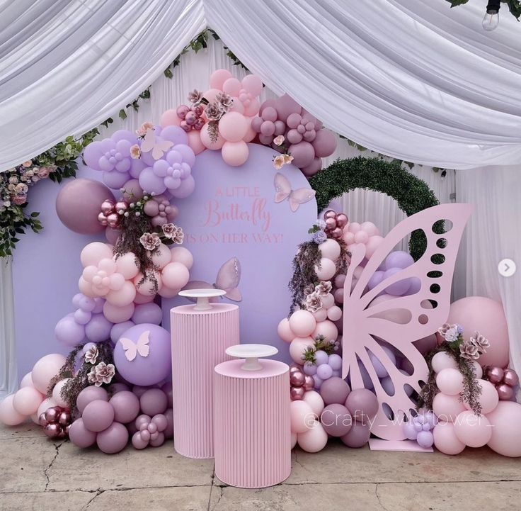 there is a large balloon arch with balloons and decorations on the wall next to it