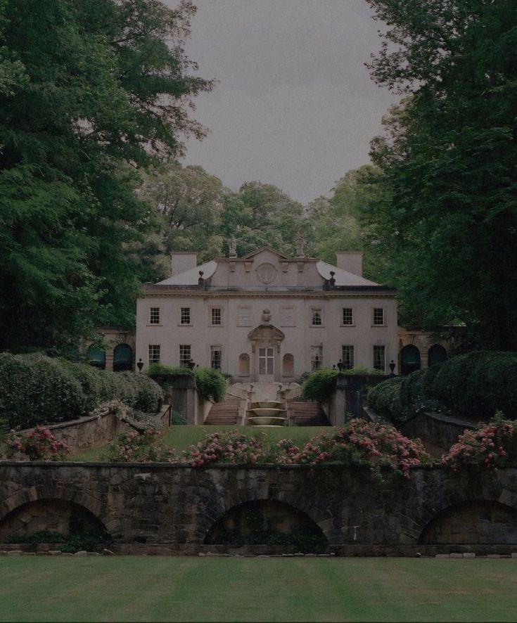 a large white house surrounded by trees and bushes