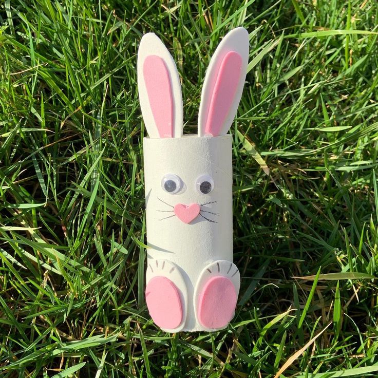 a paper roll bunny sitting in the grass