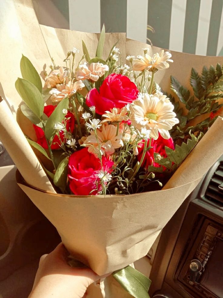 a bouquet of flowers sitting on top of a car dashboard next to an old radio