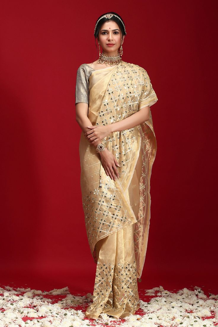 Golden saree highlighted with geometric mirror motif embroidery. Comes with blouse.
Component: 2
Embroidered
Sleeve Length: Short Sleeves
Fabric: Tissue
Color: Gold
 - Aza Fashions Transitional Gold Pre-draped Saree With Gota Work, Cotton Silk Pre-draped Saree With Mirror Work For Reception, Festive Bollywood Pre-draped Saree In Chanderi, Festive Gold Pre-draped Saree With Mirror Work, Transitional Festive Pre-draped Saree With Mirror Work, Navratri Gota Work Pre-draped Saree In Tissue Silk, Festive Pre-draped Saree With Gota Work, Cotton Silk Pre-draped Saree With Mirror Work, Festive Tissue Silk Blouse Piece With Gota Work