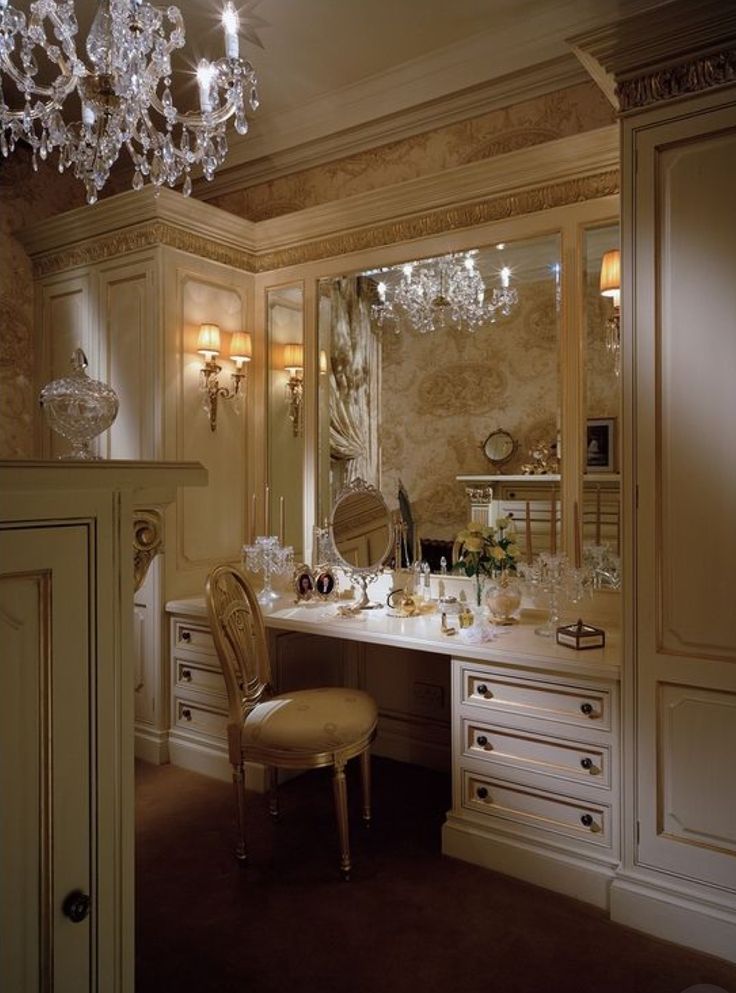 an elegant dressing room with chandelier and vanity