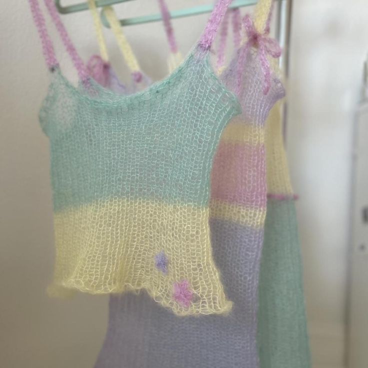 two knitted tops hanging on a clothes rack