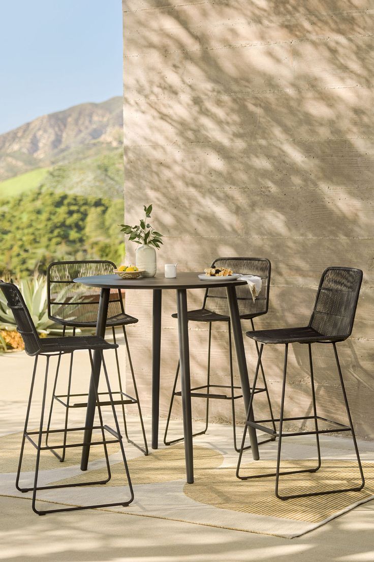 an outdoor table with two chairs next to it