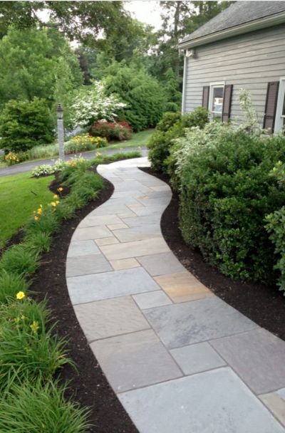 a stone walkway in front of a house