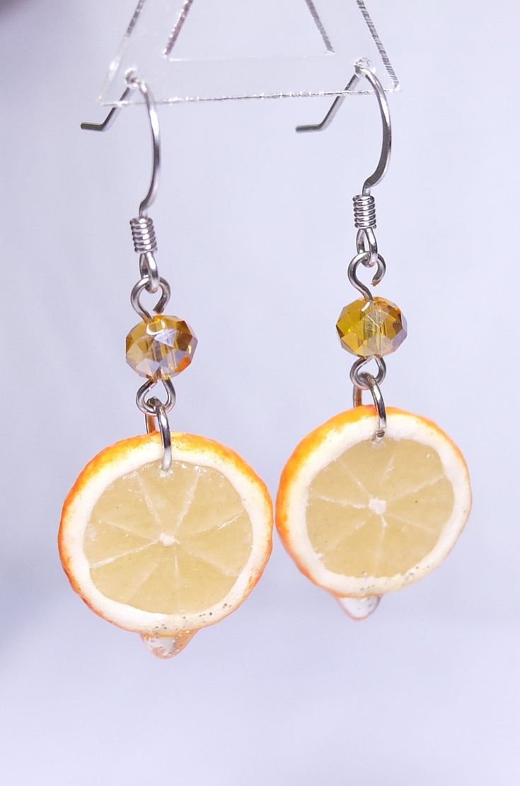 "This Miniature Sliced Orange Dangle Earrings are cute & unique.  Looks so juicy & yummy! Handmade with different clay to achieve the translucent & juicy effect, which looks totally different from molded plastic.  There are lot of steps & processes to finish this pair of earrings, thus, please allow about a week for production. Each pair comes with the sparkling beads.   The sliced oranges are small in size, only abt. 1.5 - 1.7 cm dia. / abt. 0.6 - 0.67\" dia. The rough length of the whole earring is abt. 4.5 cm L / abt. 1.77\" L. Price is for 1 pair of earrings. Made of Clay & Resin.   Unique handmade product, colors & sizes will be varied from the photos.  Other designs, like Sliced Lime & Orange Earrings are available. Please do not wear our Handmade Jewelry in the shower." Sliced Oranges, Sliced Orange, Orange Jewelry, Funny Earrings, Miniature Food Jewelry, Fruit Jewelry, Food Earrings, Fruit Earrings, Tea Bag Holder