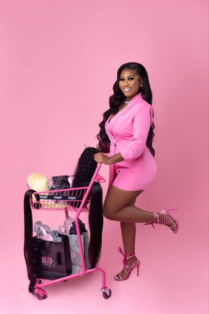 a woman in a pink dress standing next to a shopping cart with her hair on it