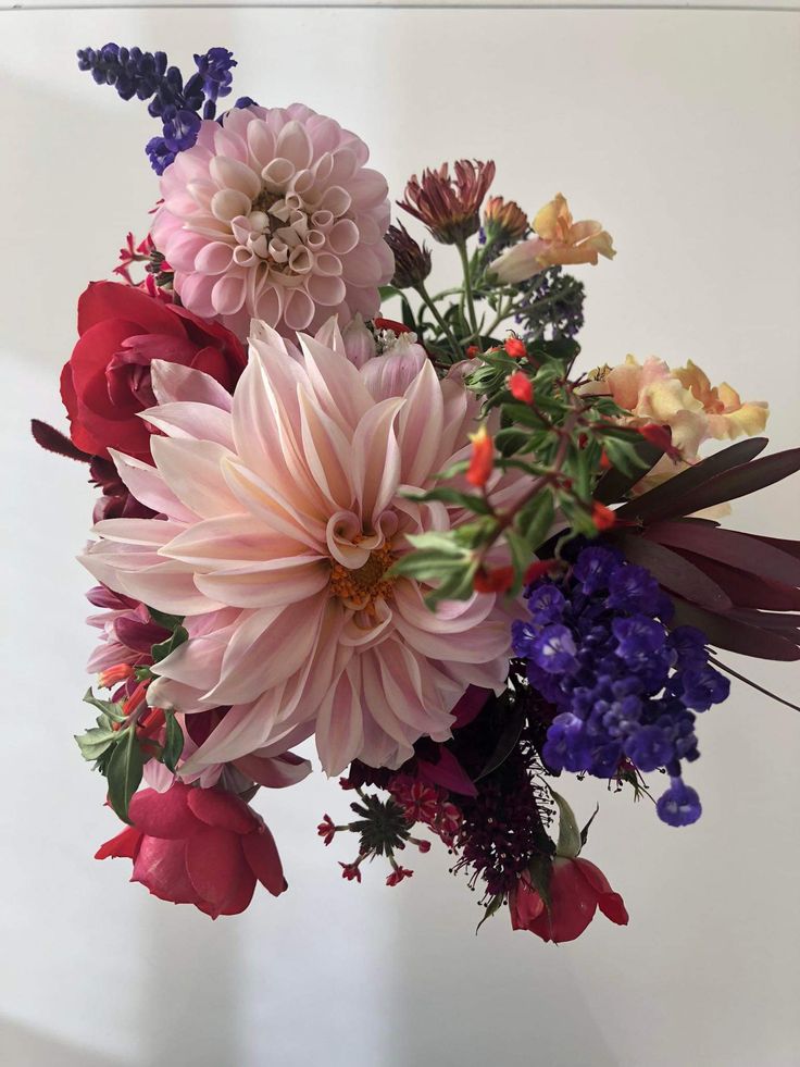 a vase filled with lots of different colored flowers