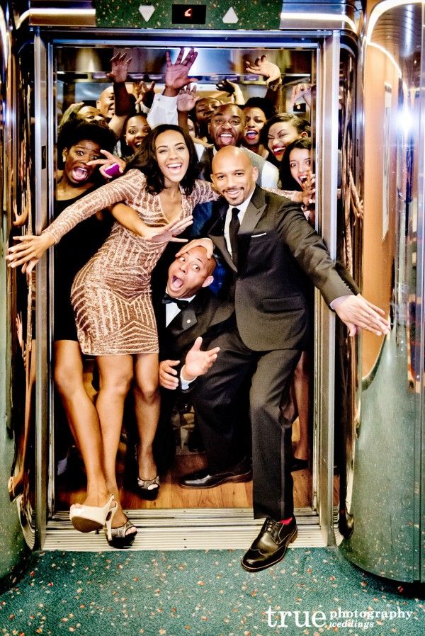 a group of people standing on top of an elevator with their hands in the air